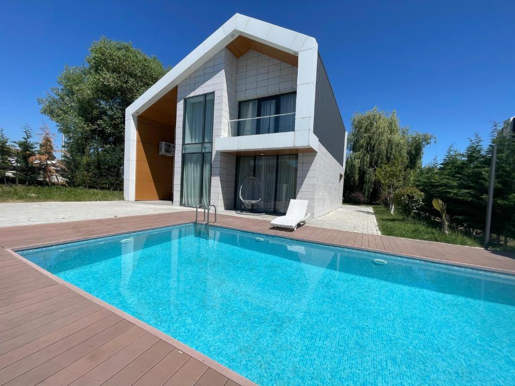 a house with a swimming pool in front of a house at Arena Apartments & Villas Guba in Quba
