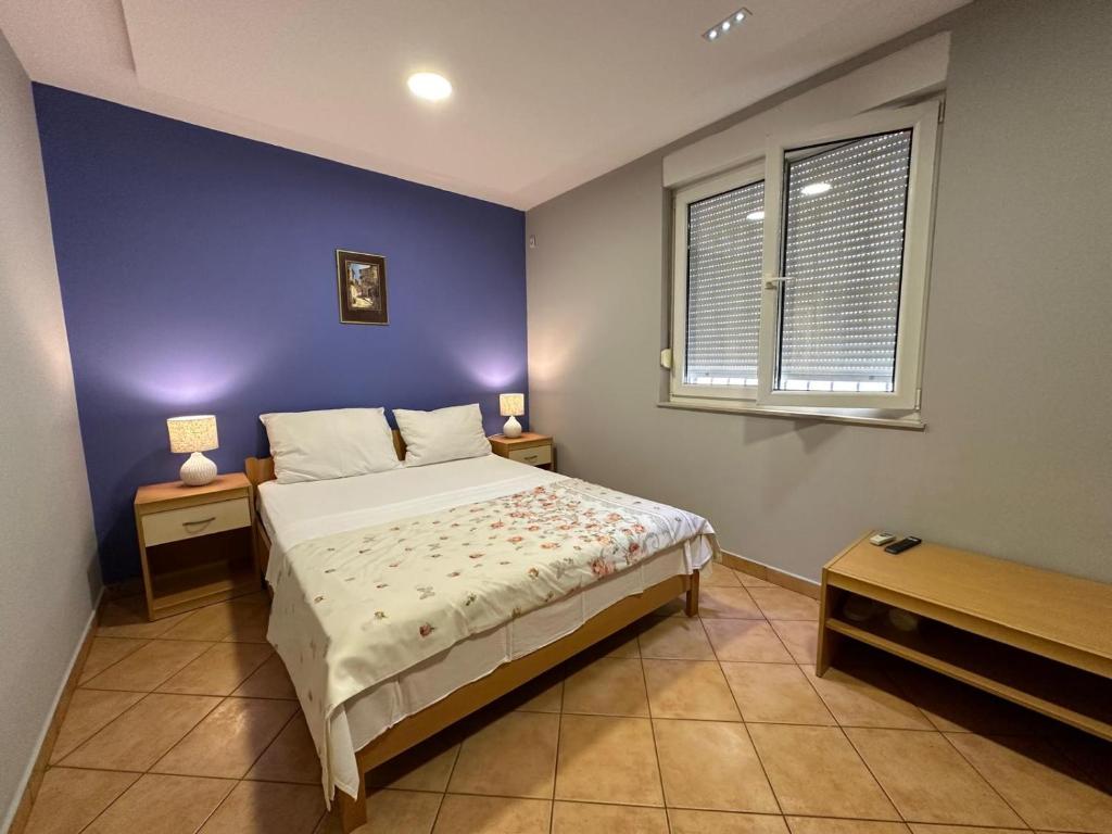 1 dormitorio con cama y pared azul en Villa la Riva, en Mostar