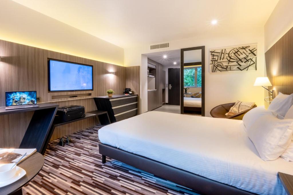 トゥールーズにあるNemea Appart Hotel Concorde Toulouse Gare Matabiauのベッド1台、薄型テレビが備わるホテルルームです。