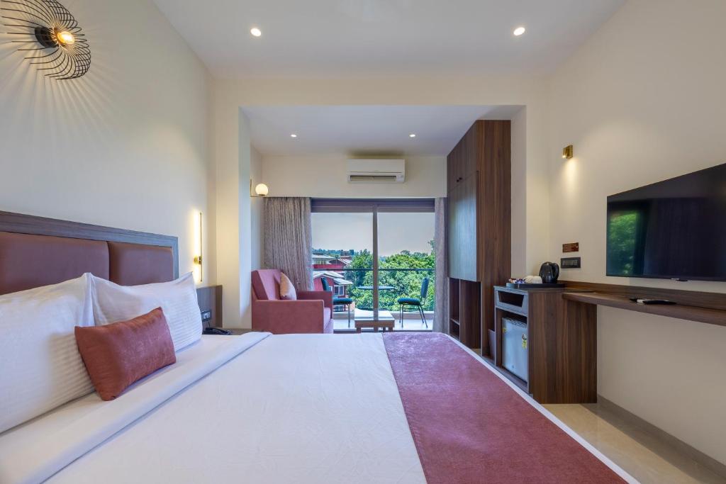a hotel room with a large bed and a television at Bella Vista Mahabaleshwar in Mahabaleshwar