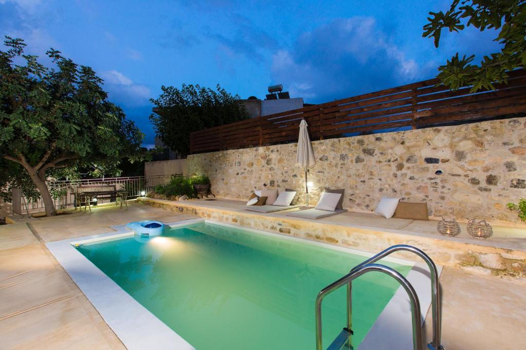 a swimming pool in front of a stone wall at Dotira in Mési