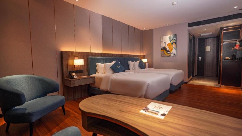 una camera d'albergo con letto, sedia e tavolo di FUGO Hotel Samarinda a Samarinda