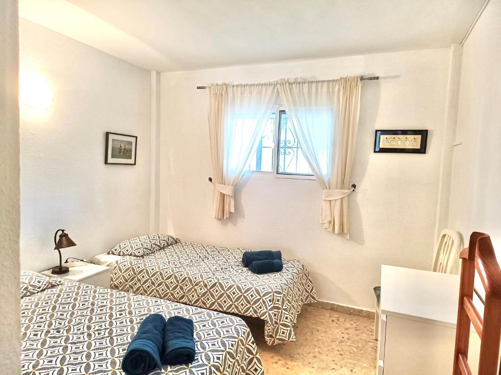 A bed or beds in a room at APARTAMENTO AGUAMARINA Nsf54 -NERJA