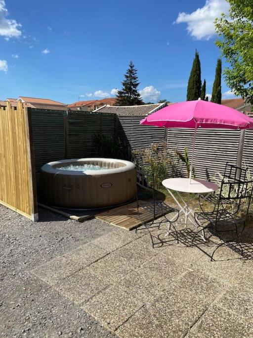 - un bain à remous avec une table et un parasol dans l'établissement Chalet avec SPA à Biscarrosse, à Biscarrosse