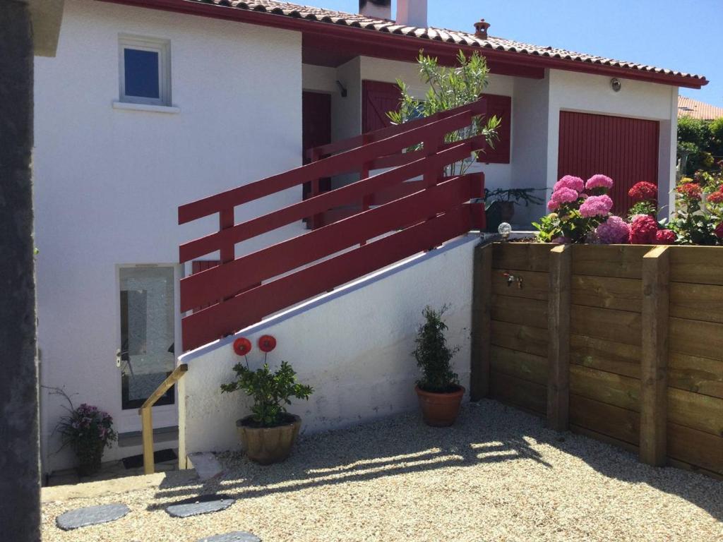une maison avec une clôture et des fleurs devant elle dans l'établissement T1 Bis Charmant à Bidart, 2 Pers, 900m Plage, Terrasse et Spa, Quartier Calme - FR-1-495-137, à Bidart
