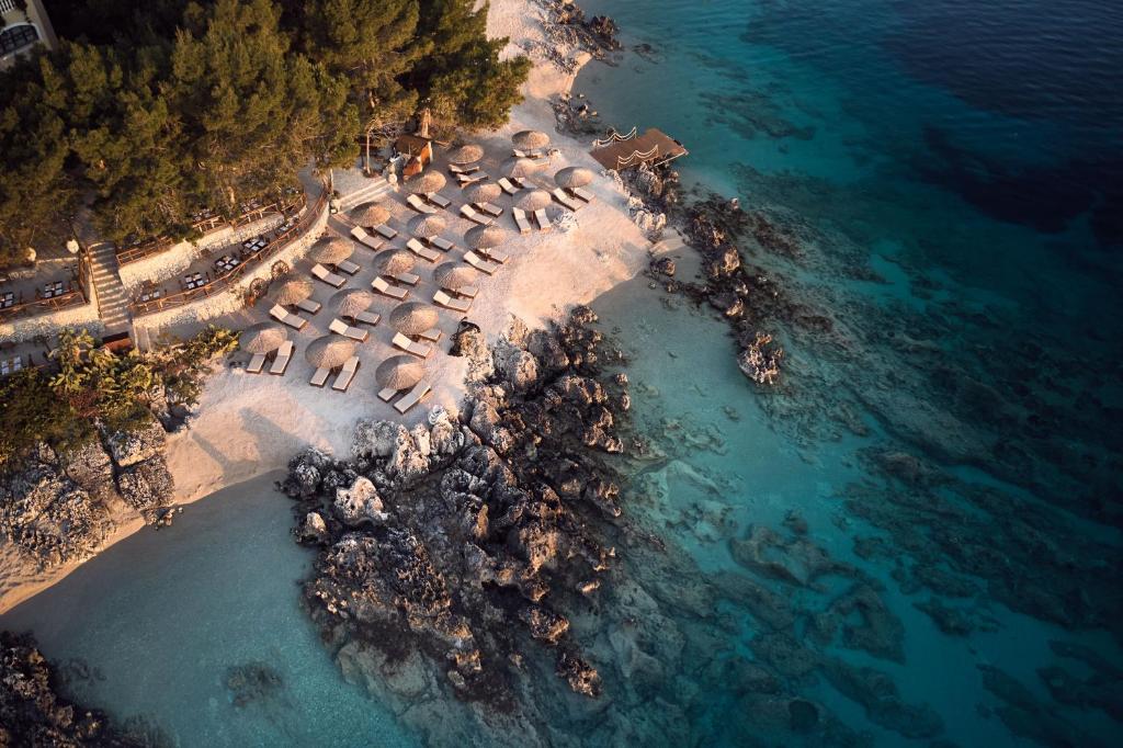 een luchtzicht op een strand met een groep parasols bij Nobelos Seaside Lodge in Agios Nikolaos