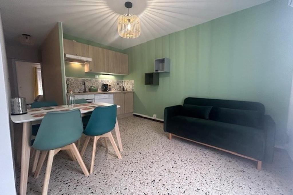 un salon avec un canapé, une table et des chaises dans l'établissement 2 air-conditioned rooms in villa by the sea, à Frontignan