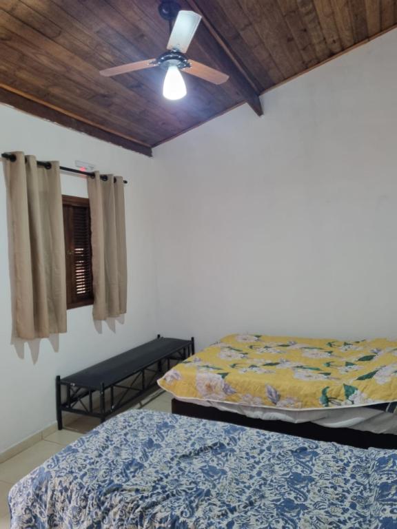 een slaapkamer met 2 bedden en een plafondventilator bij Recanto Videira Rota do Vinho in São Roque
