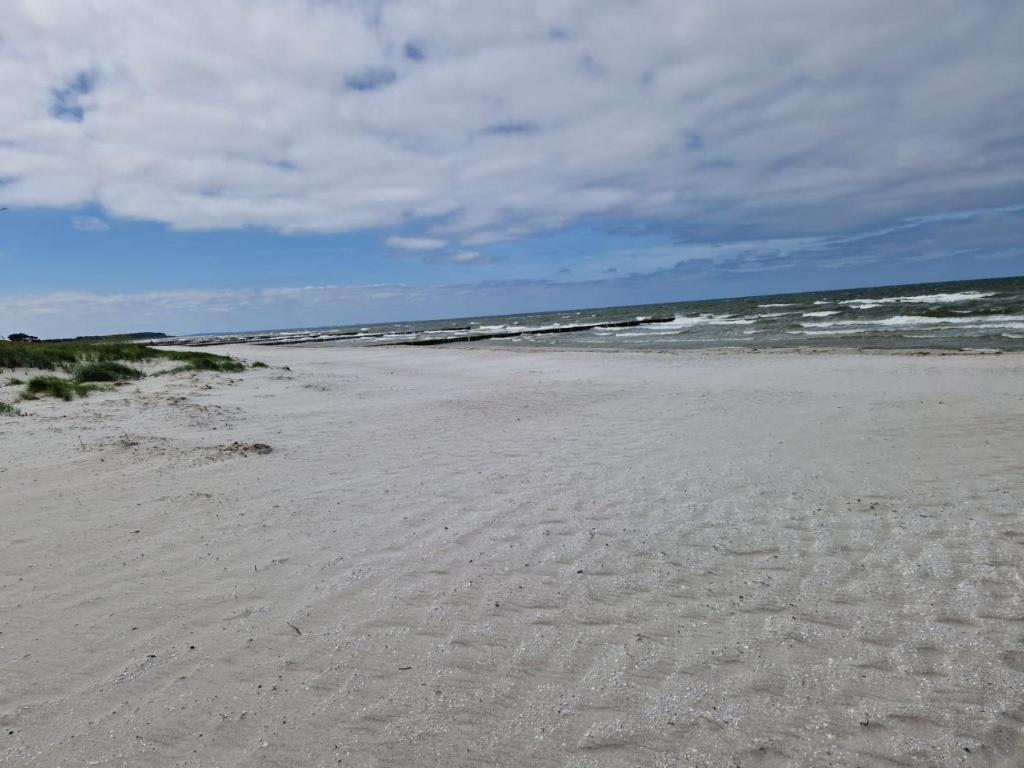 a sandy beach with the ocean in the background at Strand und Ferienhaus ,,MARSI'' am Wasser in Rappin