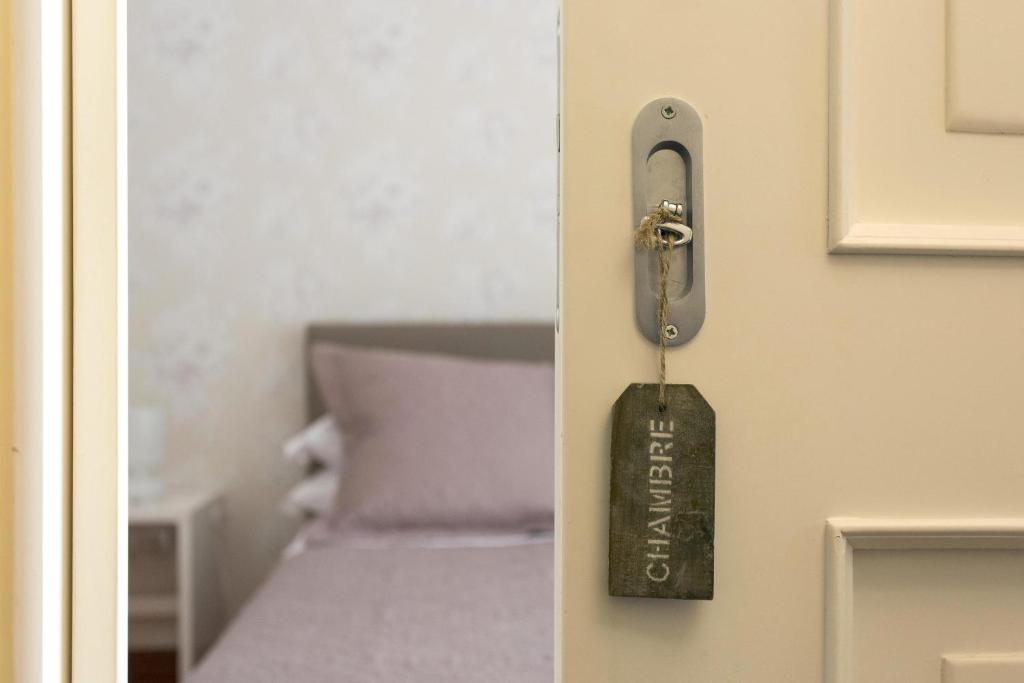 un pomo de puerta con una etiqueta en una puerta con una cama en Casa Esposito, en Nápoles