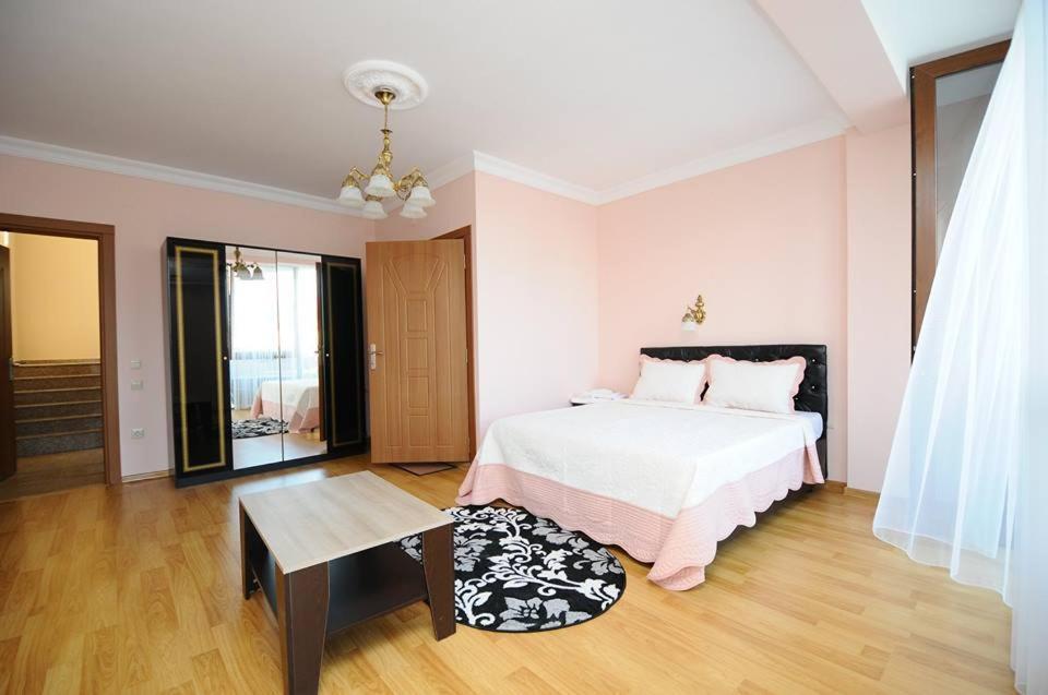 a bedroom with a white bed and a wooden floor at Hotel ''Premium Palace'' in Batumi