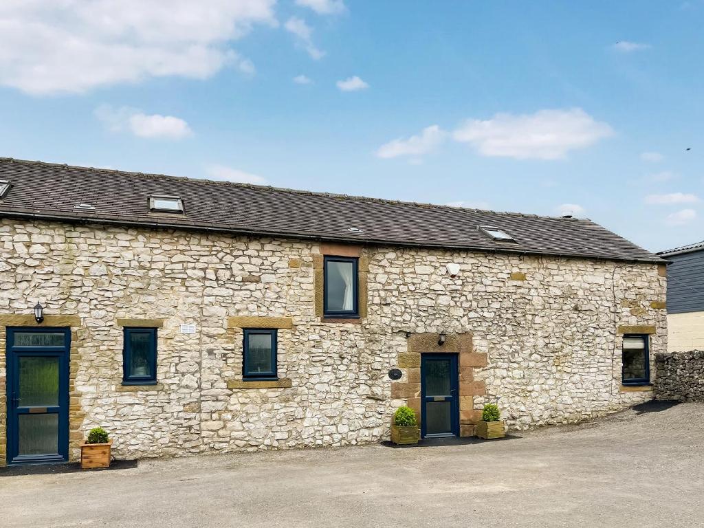 a stone building with two doors and windows at Honeysuckle Cottage - 27880 in Elton