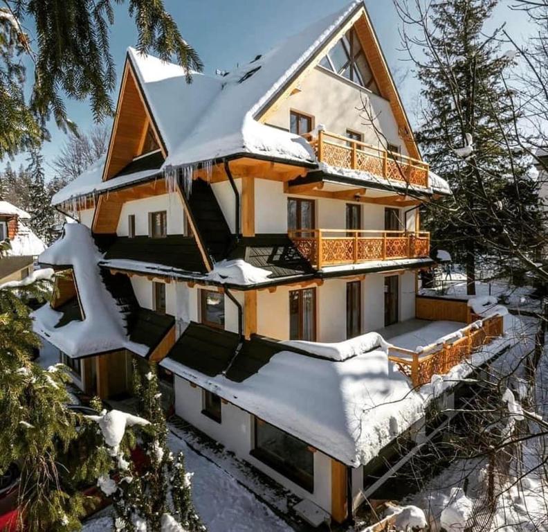 a house covered in snow in the snow at Villa Kaplowa Chata & SPA in Zakopane