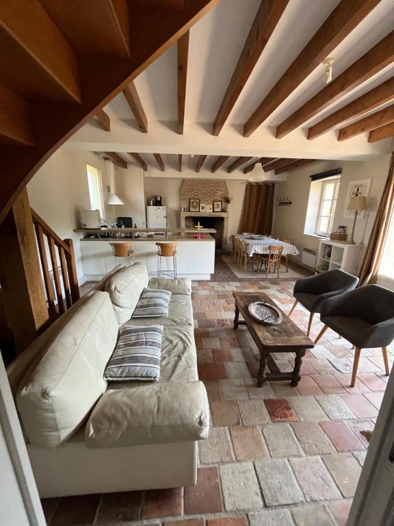 a living room with a white couch and a kitchen at Gite Du Bec De Cisse in Vouvray