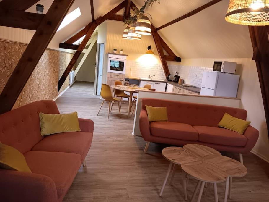 un salon avec deux canapés et une cuisine dans l'établissement Gite la pause picarde, à Franleu