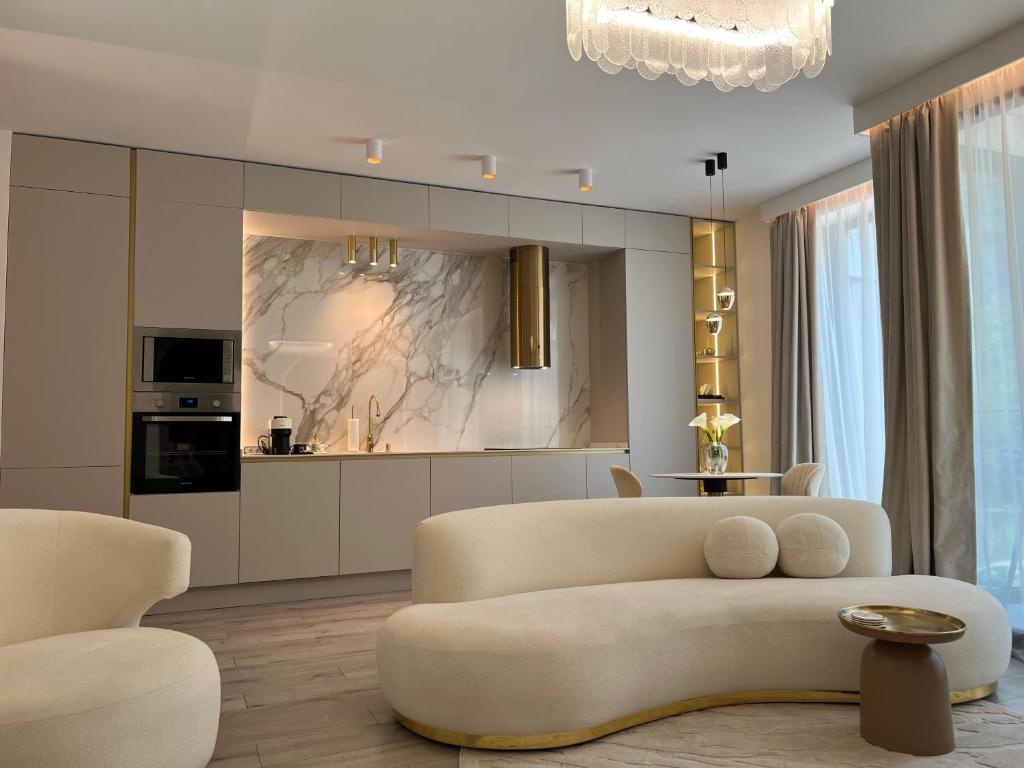 a living room with a couch and a kitchen at Harmony Property WIN HERASTRAU in Bucharest