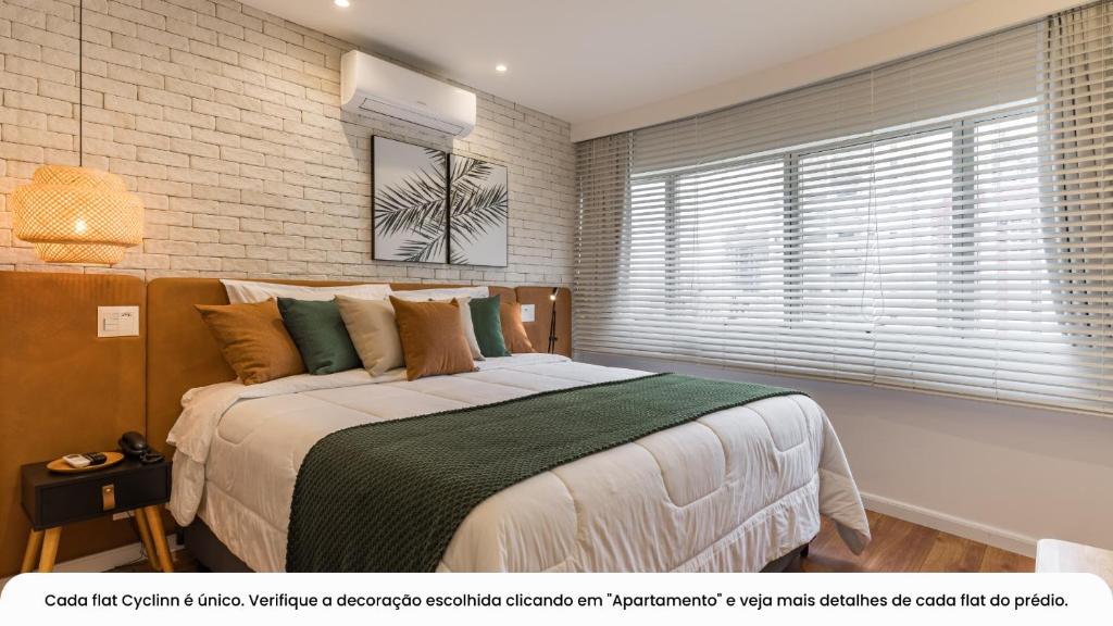 1 dormitorio con 1 cama grande y pared de ladrillo en Cyclinn Berrini, en São Paulo