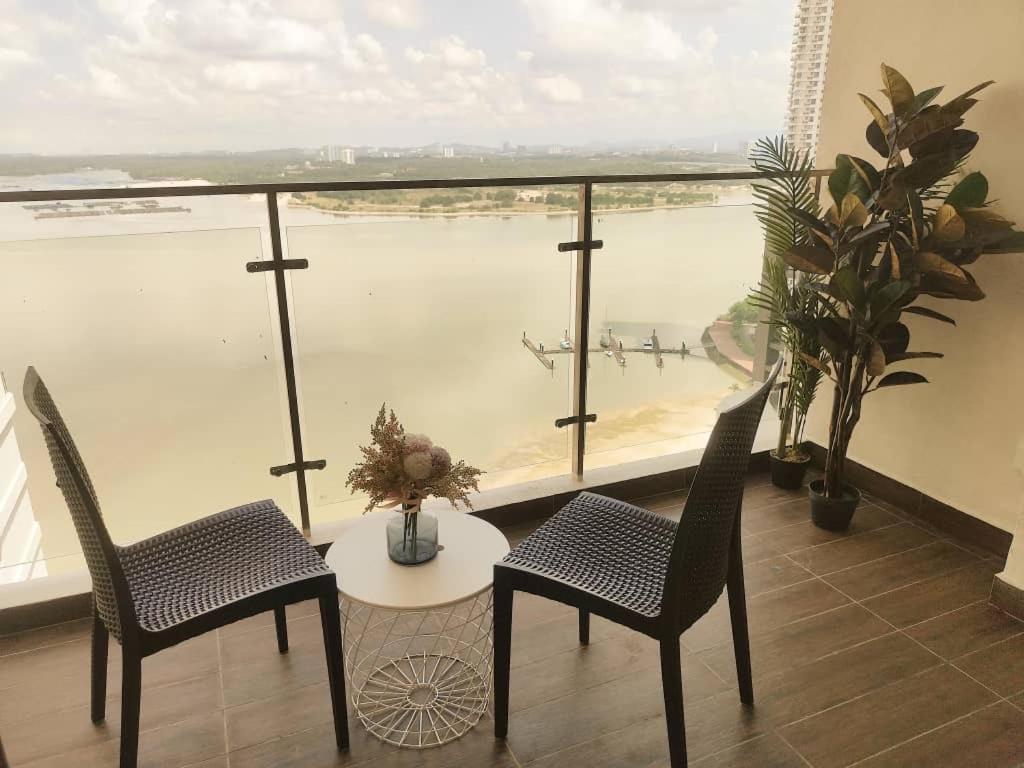 a room with a table and chairs and a view of the water at 海景套房 3房3厕 可8-12人Danga Bay Country Garden YI JIA名宿 in Johor Bahru