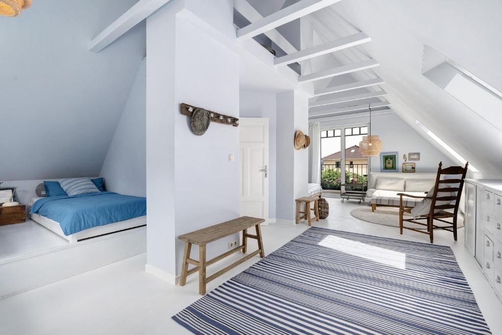 a bedroom with a blue bed and a living room at Ferienhaus Karinella in Gronenberg