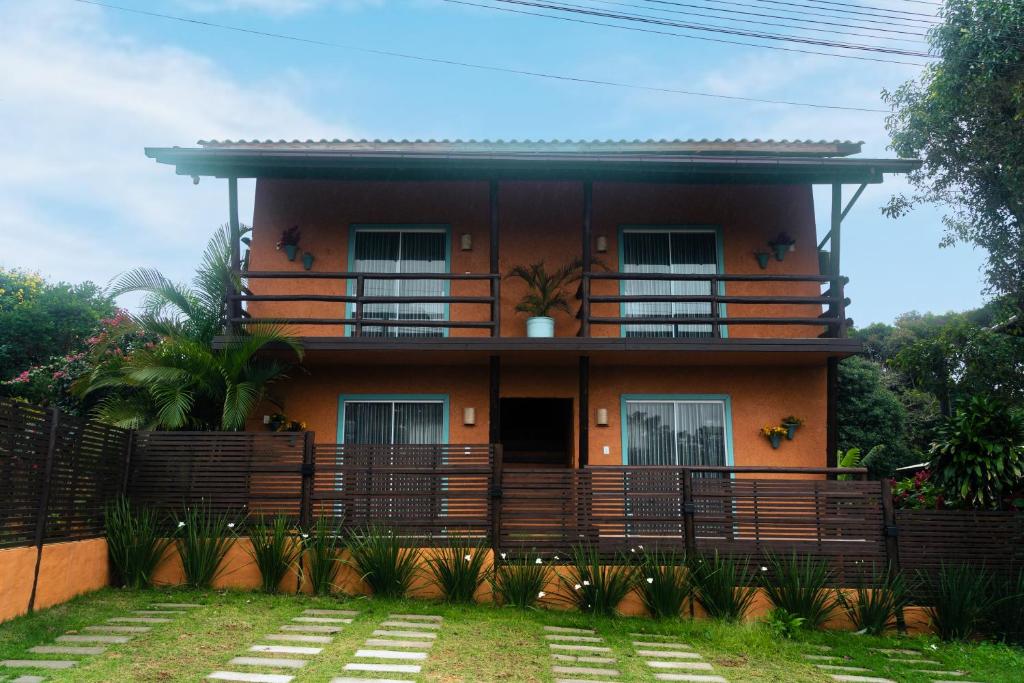 a house with a fence in front of it at Namaste Flats Praia do Rosa in Imbituba