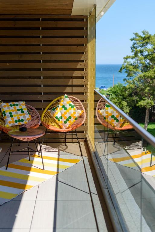 three chairs with colorful pillows sitting on a balcony at Astria Eclipse - Complex Novum in Olimp
