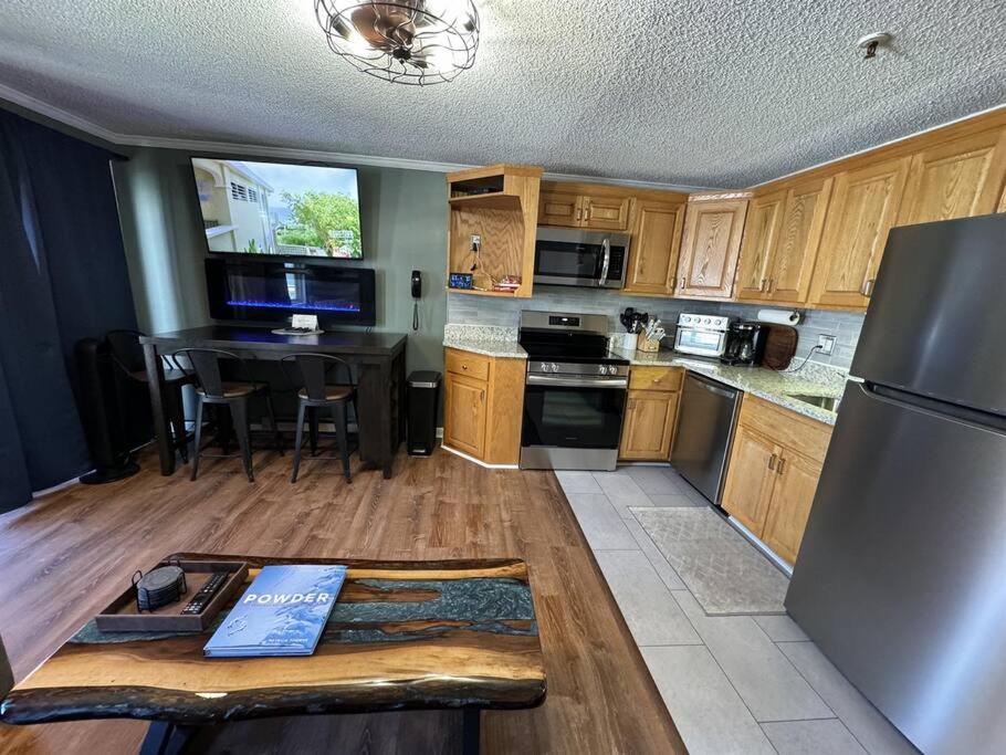 a kitchen with wooden cabinets and a stainless steel refrigerator at Stroll to Slopes, Village Area, Ski in-out MtLodge 308 in Snowshoe
