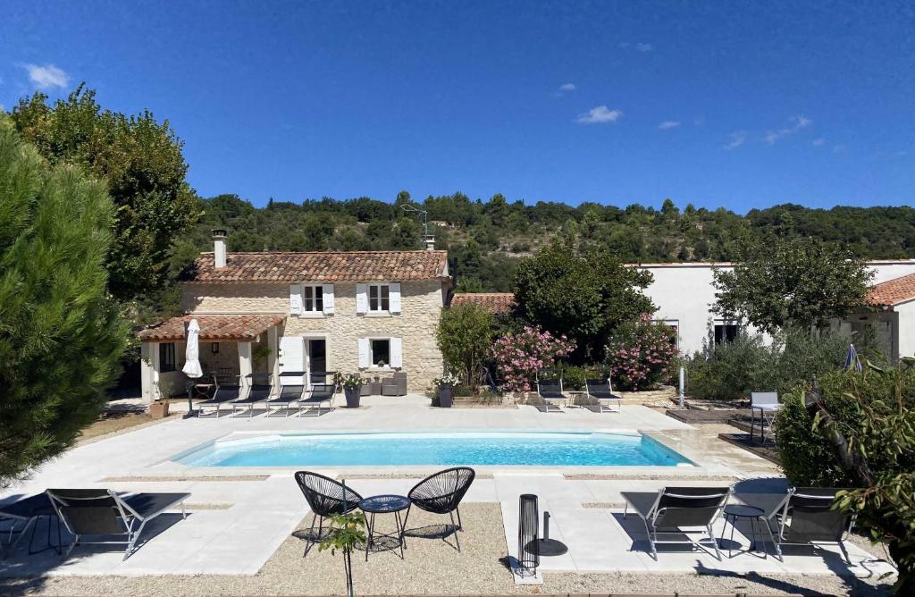 a villa with a swimming pool in front of a house at Le Cabanon de Marie in Saignon