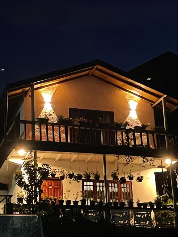 un edificio con balcone di notte illuminato di Cozy Heaven a Nuwara Eliya