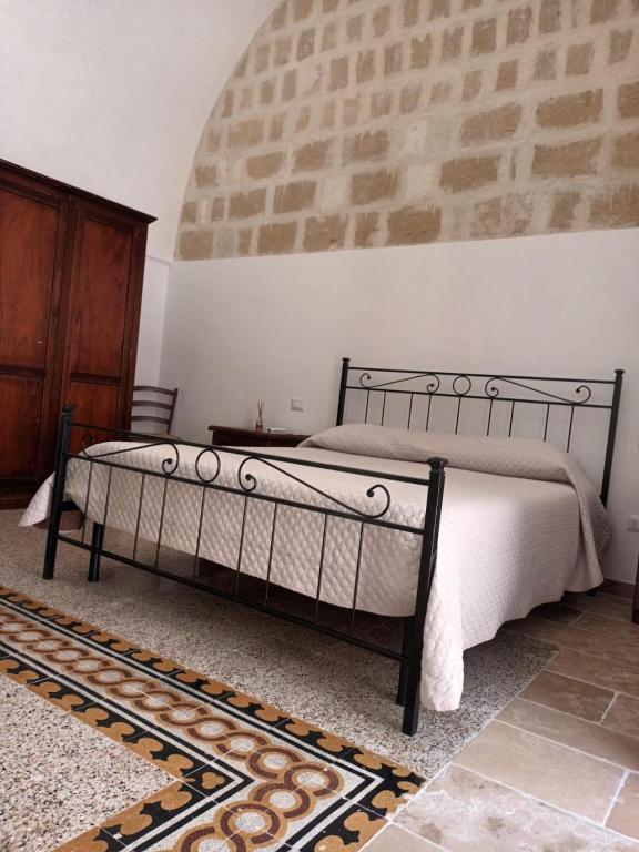 a bedroom with a bed and a brick wall at Dimora '900 in Poggiorsini