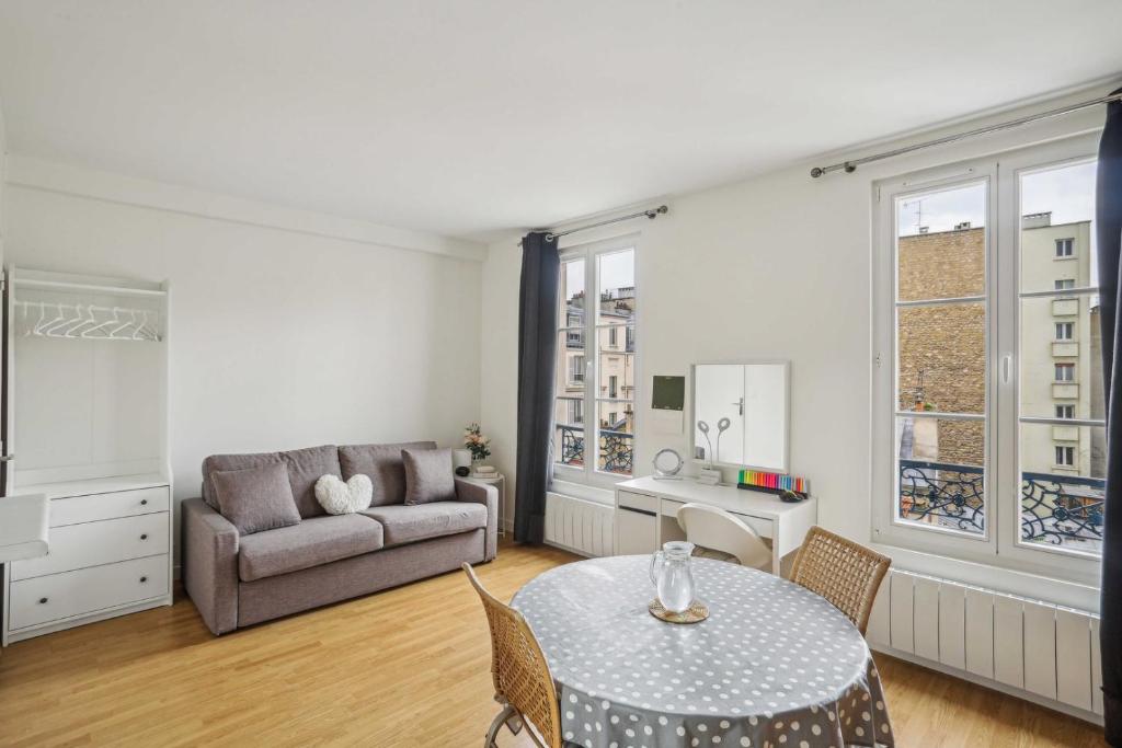 un salon avec une table et un canapé dans l'établissement L'Adorable, à Paris