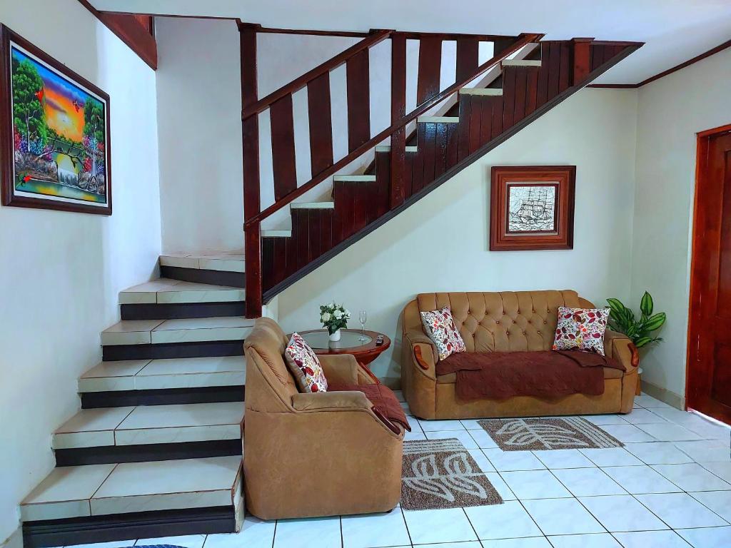 een woonkamer met een bank en een trap bij Casa equipada en el centro de Puntarenas in Puntarenas