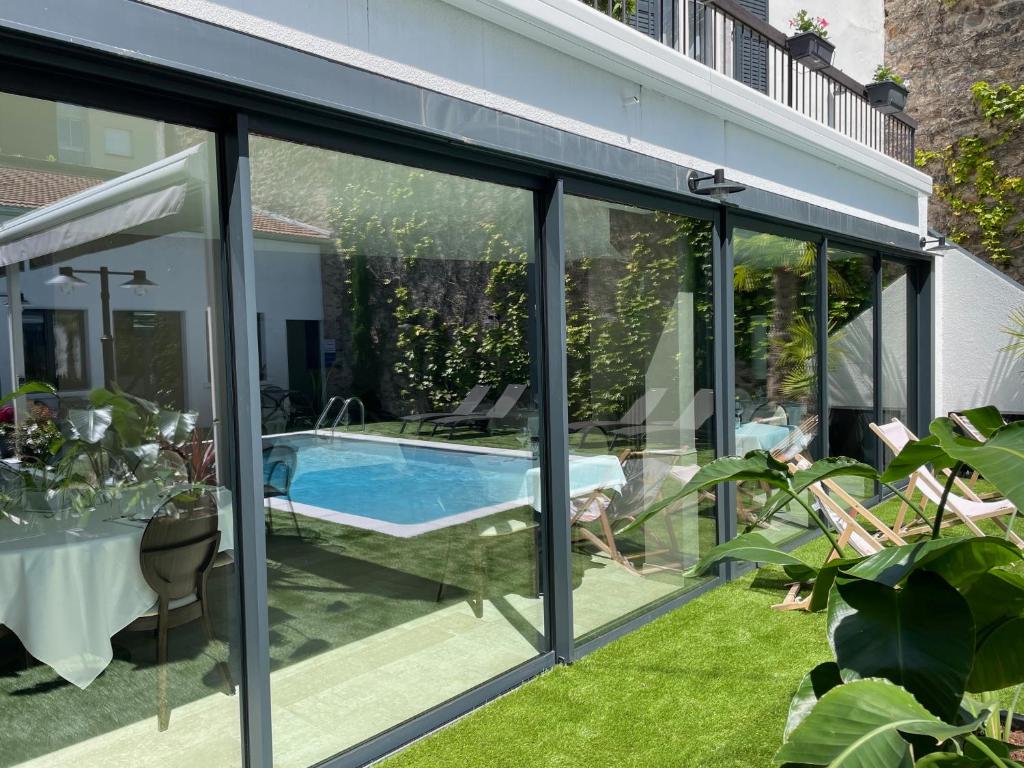 uma extensão de vidro de uma casa com piscina em Le Pavillon d'Enghien, Vichy Centre em Vichy