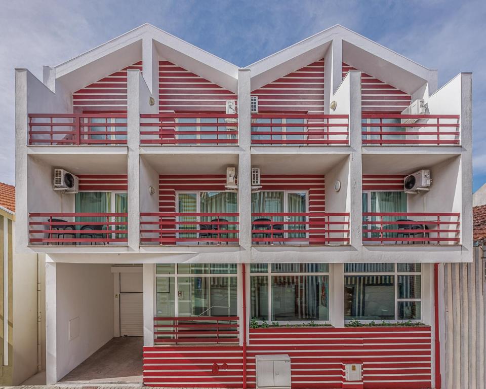 a red and white building with red balconies at Costa Nova Hotel in Costa Nova