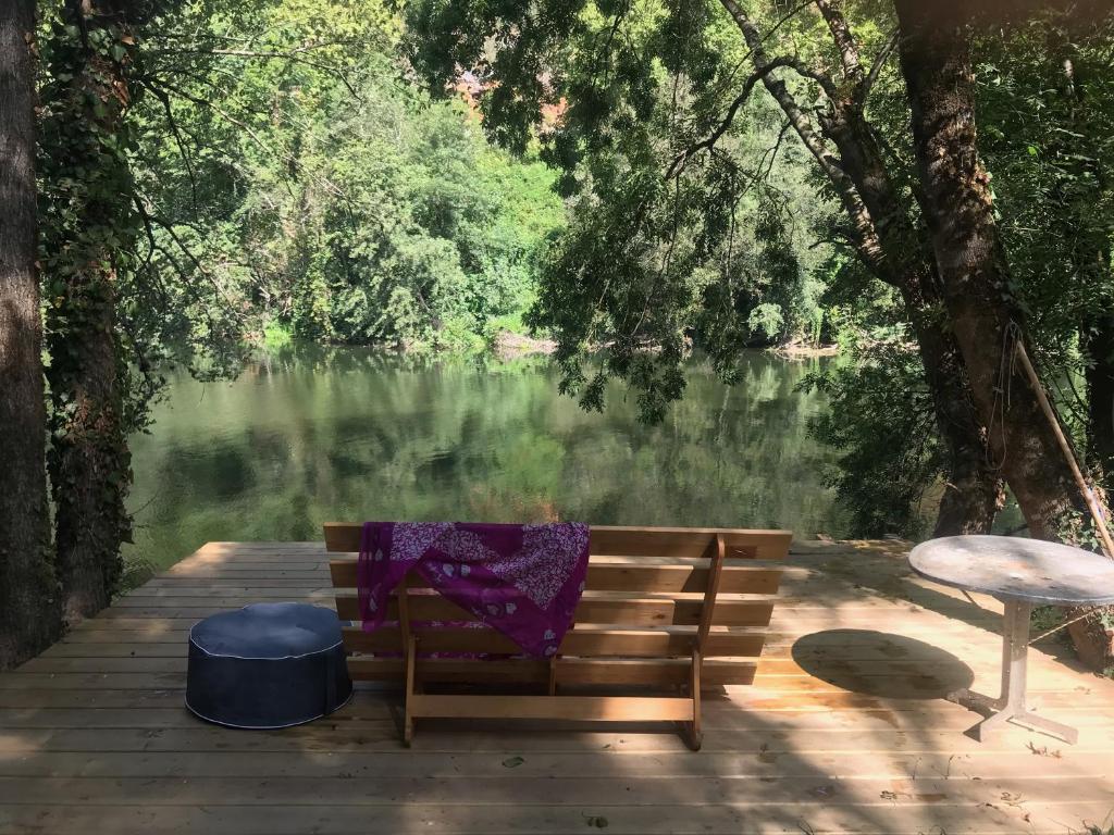 un banc assis sur un quai à côté d'un lac dans l'établissement gite la bergerie en bord d'Aveyron, à Saint-Antonin