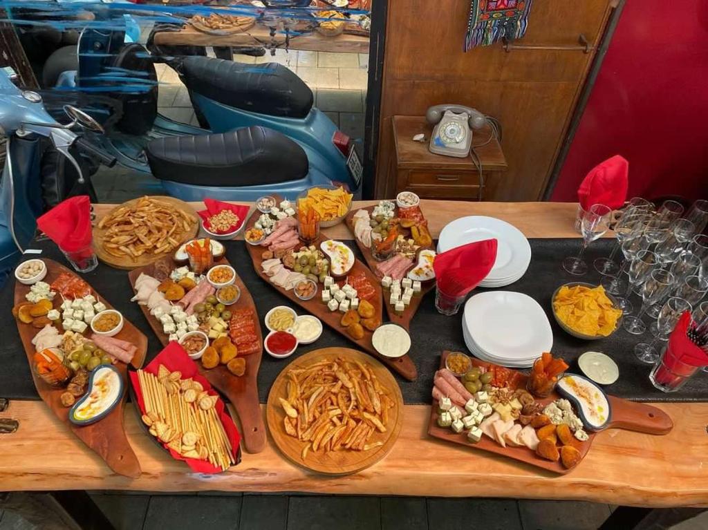 a table with a bunch of different types of food at Divina Hostel in Tirana