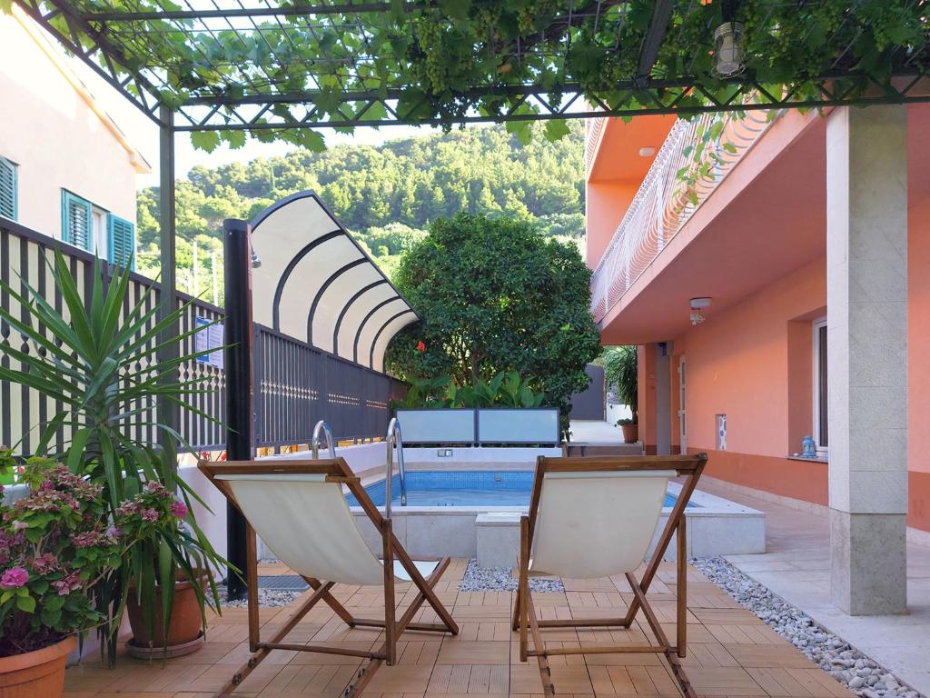 a patio with two chairs and a swimming pool at Apartment Marjan Park in Split