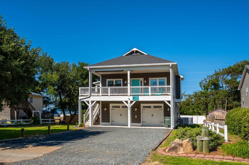 une maison avec un balcon et un garage dans l'établissement Voyage Anchor, à Nags Head