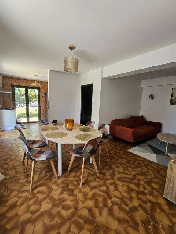 un salon avec une table, des chaises et un canapé dans l'établissement Appartement F3 meublé et équipé, à Saint-Cyprien