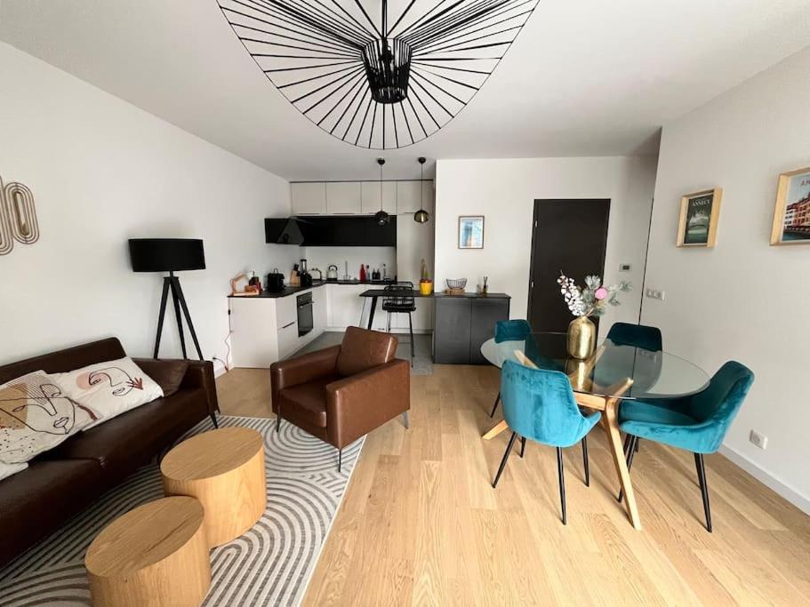 un salon avec un canapé, une table et des chaises dans l'établissement La Scène du Lac - Au bord du Lac avec Garage, à Annecy