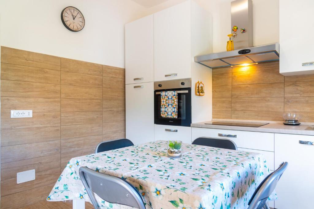 a kitchen with a table and chairs and a clock at Appartamento Il Mare Dalla Terrazza in Rio nellʼElba
