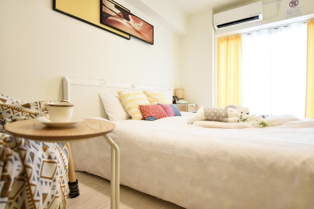 una camera da letto con un grande letto bianco e un tavolo di OSAKA SUNSHINE TOWER92 ad Osaka