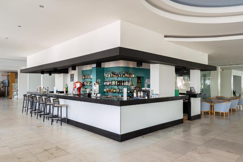 a bar in a lobby with chairs and a counter at Jupiter Algarve Hotel in Portimão