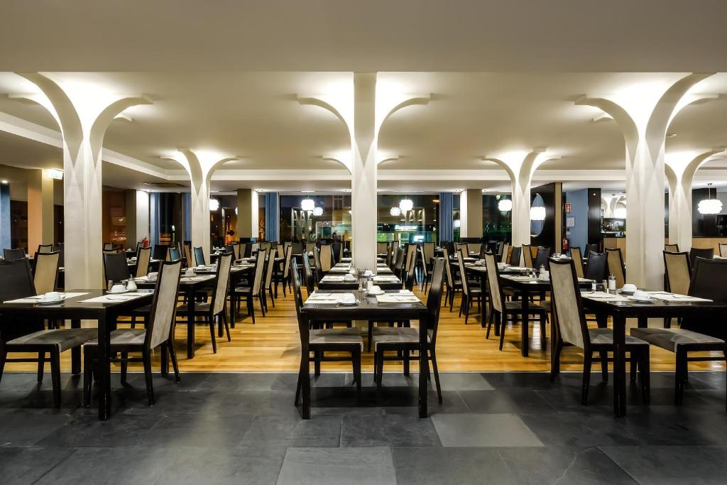 a dining room filled with tables and chairs at Jupiter Algarve Hotel in Portimão