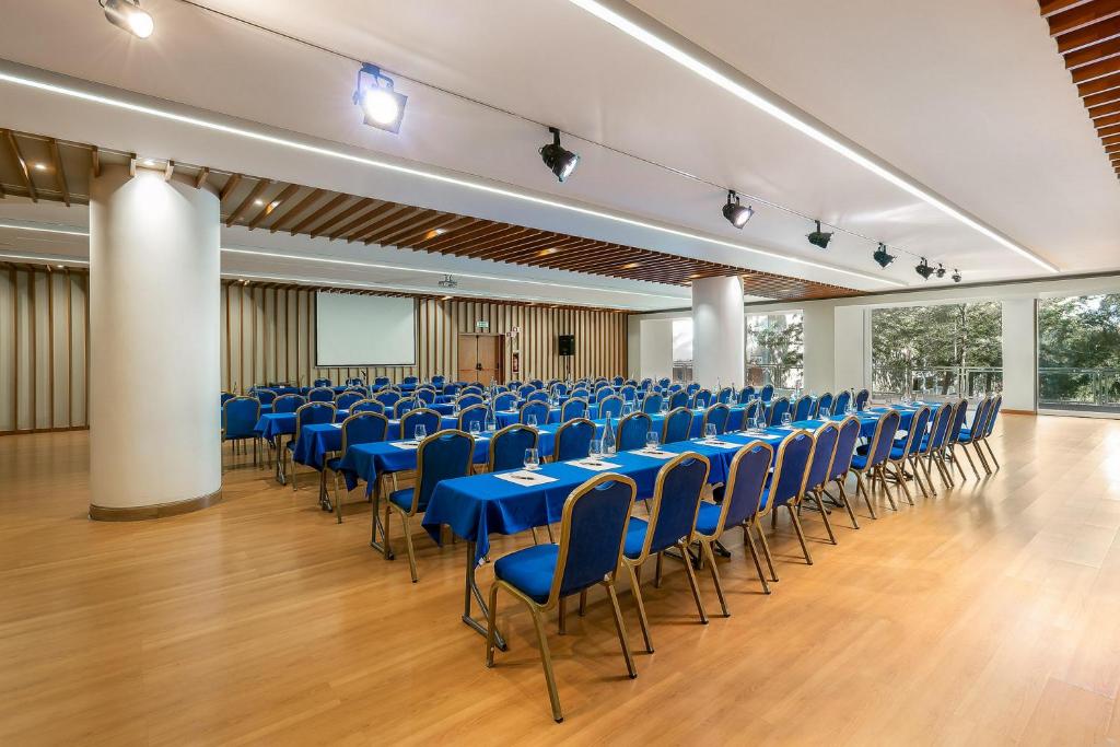 a large room with blue tables and chairs at Jupiter Algarve Hotel in Portimão
