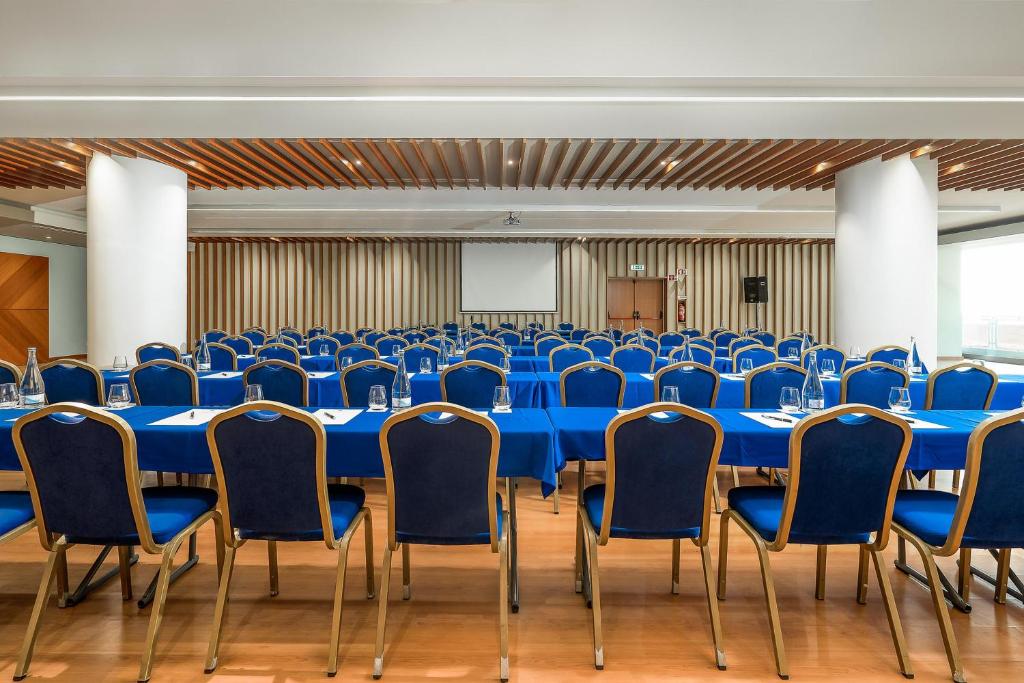 a conference room with blue tables and chairs at Jupiter Algarve Hotel in Portimão