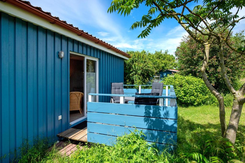 レリクにあるMöve Aba Bungalow 60の青い家 庭にデッキ付