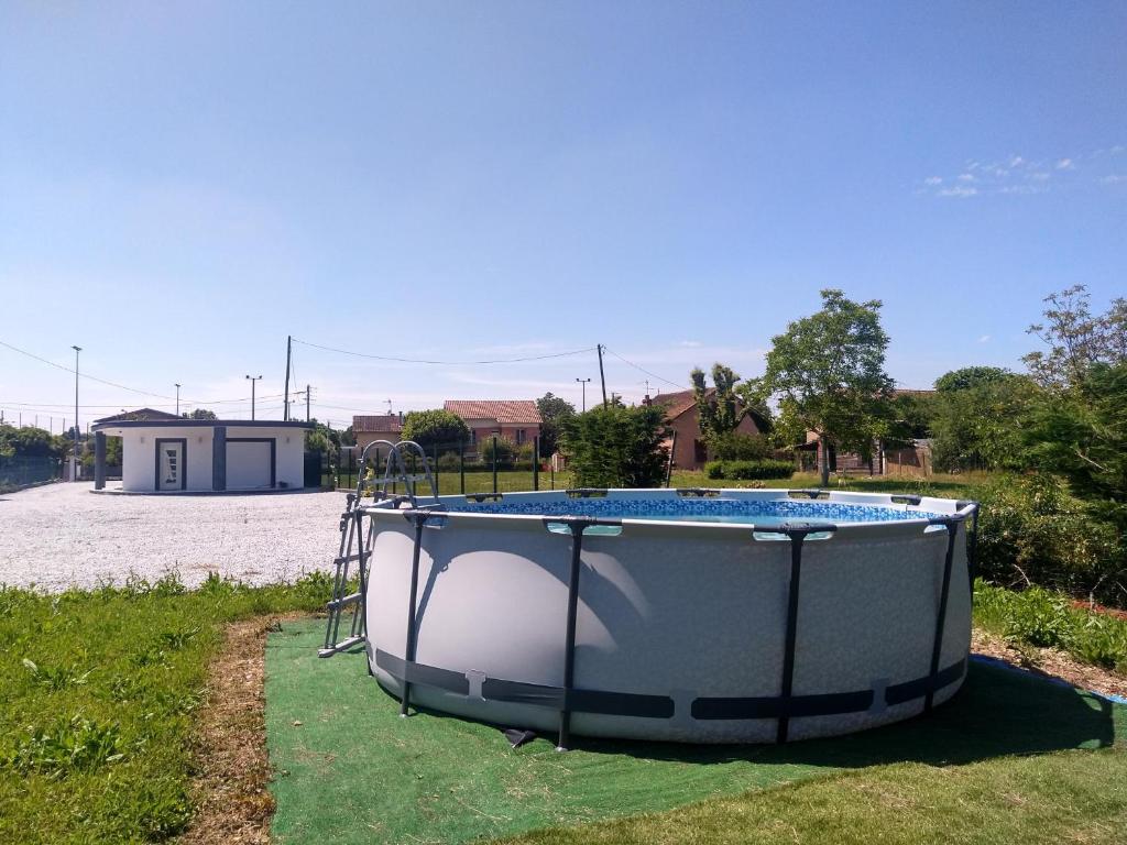 uma pequena piscina num quintal com um baloiço em Magnifique maison moderne et atypique au mobilier italien - quartier Sapiac - Piscine et parking privés gratuits - Climatisation em Montauban