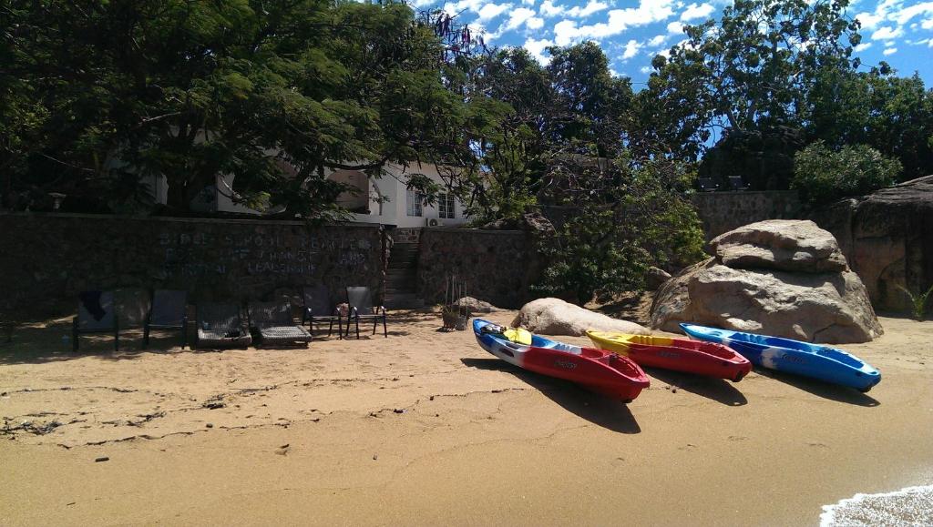 - un groupe de bateaux assis sur la plage dans l'établissement Kuwona Cottage, à Senga