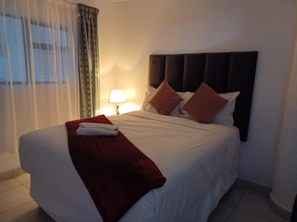 Un dormitorio con una cama grande y una ventana en De Bliss Lodge, en Johannesburgo