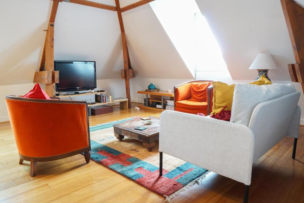 un salon avec un canapé et une télévision dans l'établissement EXIGEHOME - T3 centre-ville proche de Paris la Défense, Champs Elysée, à Rueil-Malmaison